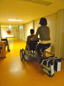 Membres de Ddd testant un fauteuil roulant poussé par un vélo, Apeldoorn, Pays-Bas.